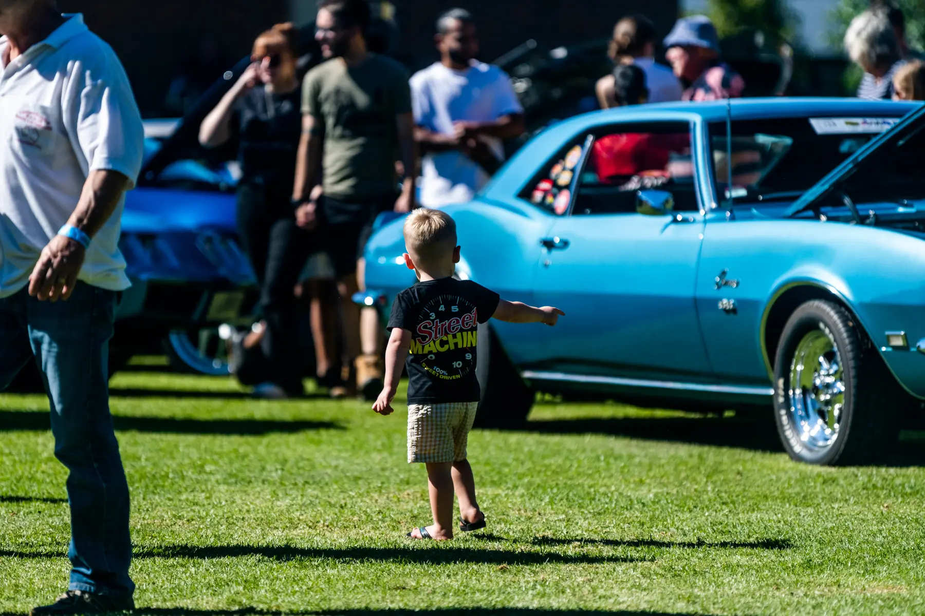 Young enthusiast walking through the Camaro Firebird Nationals