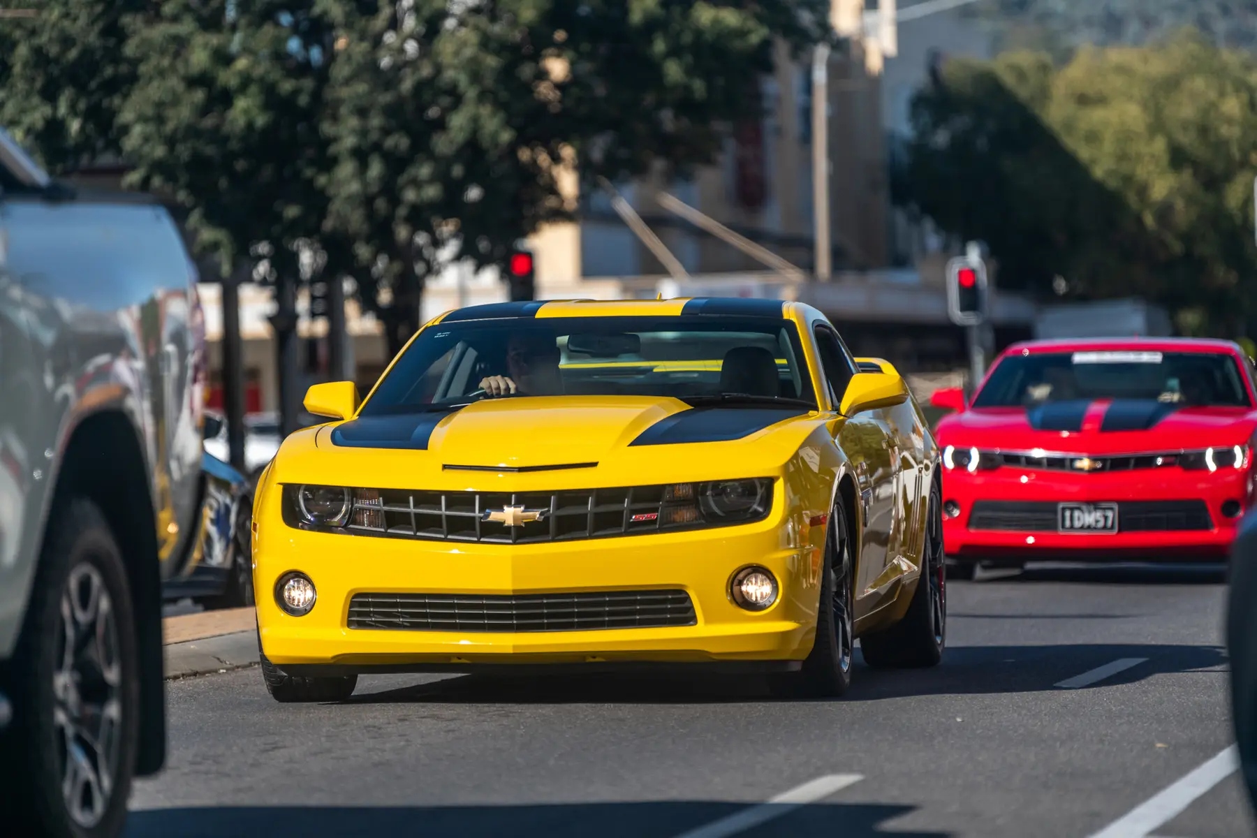 Yellow and red modern Camaros driving through central Albury