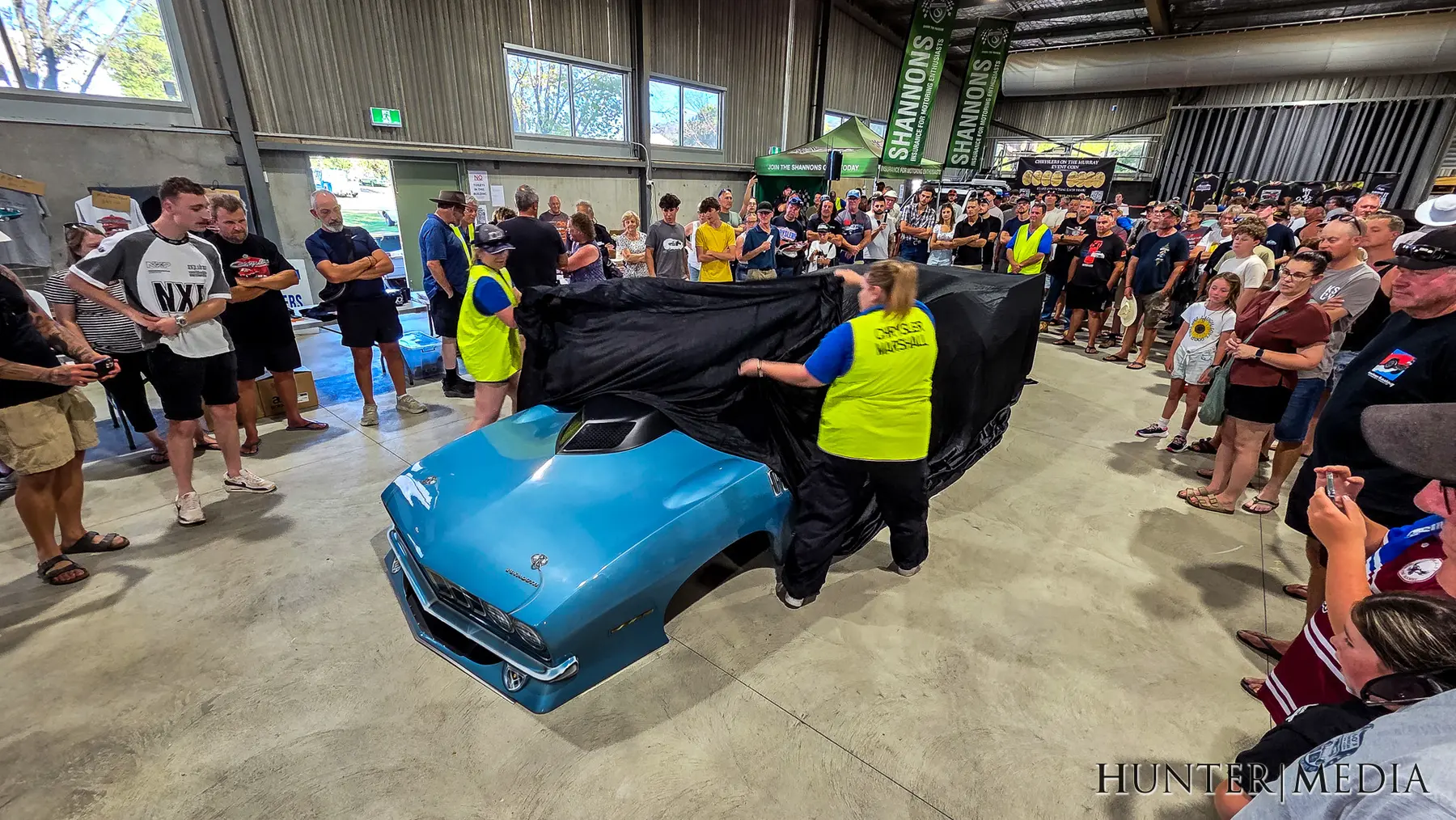 A blue Plymouth being unveiled in front of a crowd at Chryslers on the Murray