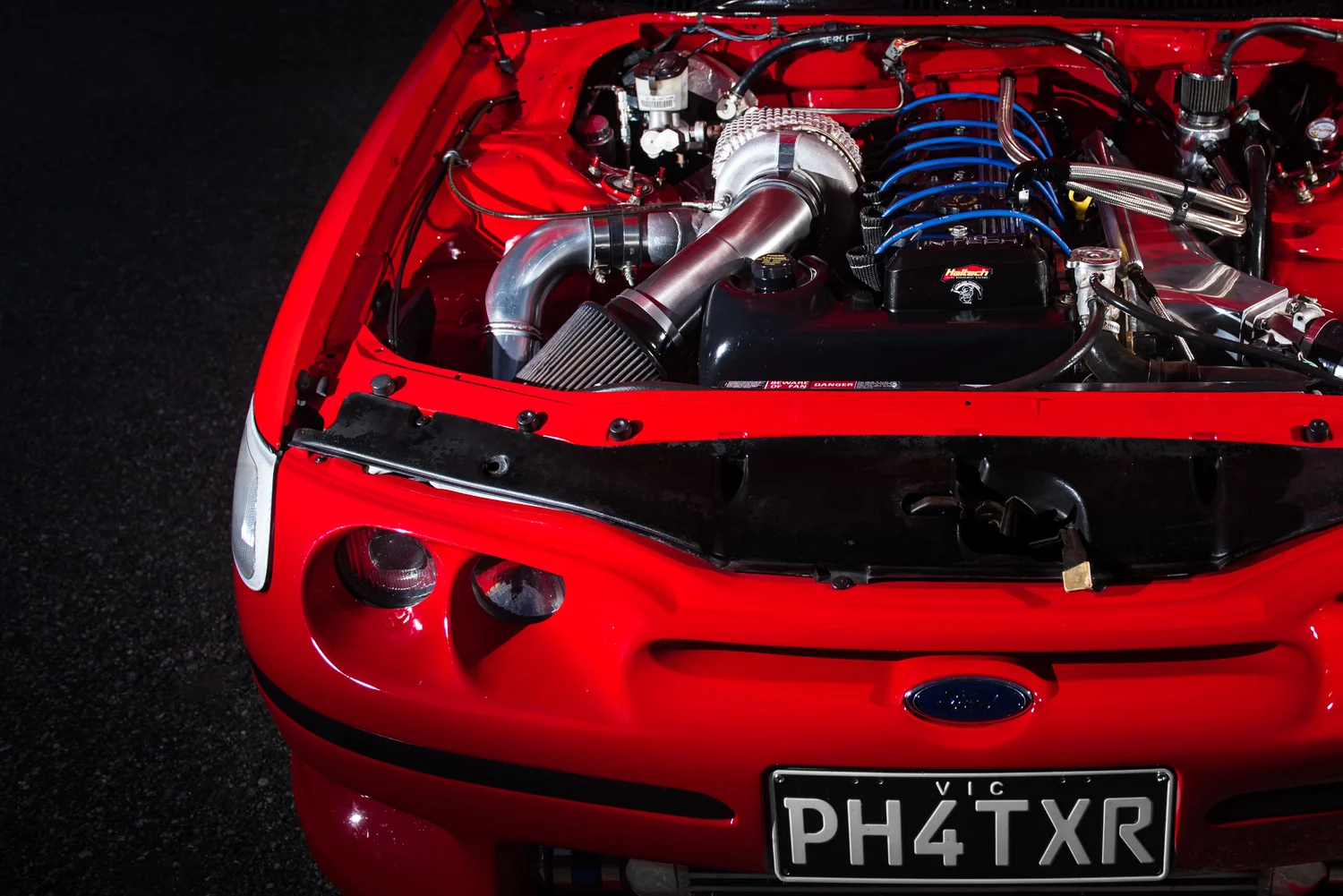 Detailed engine bay of a modified red Ford