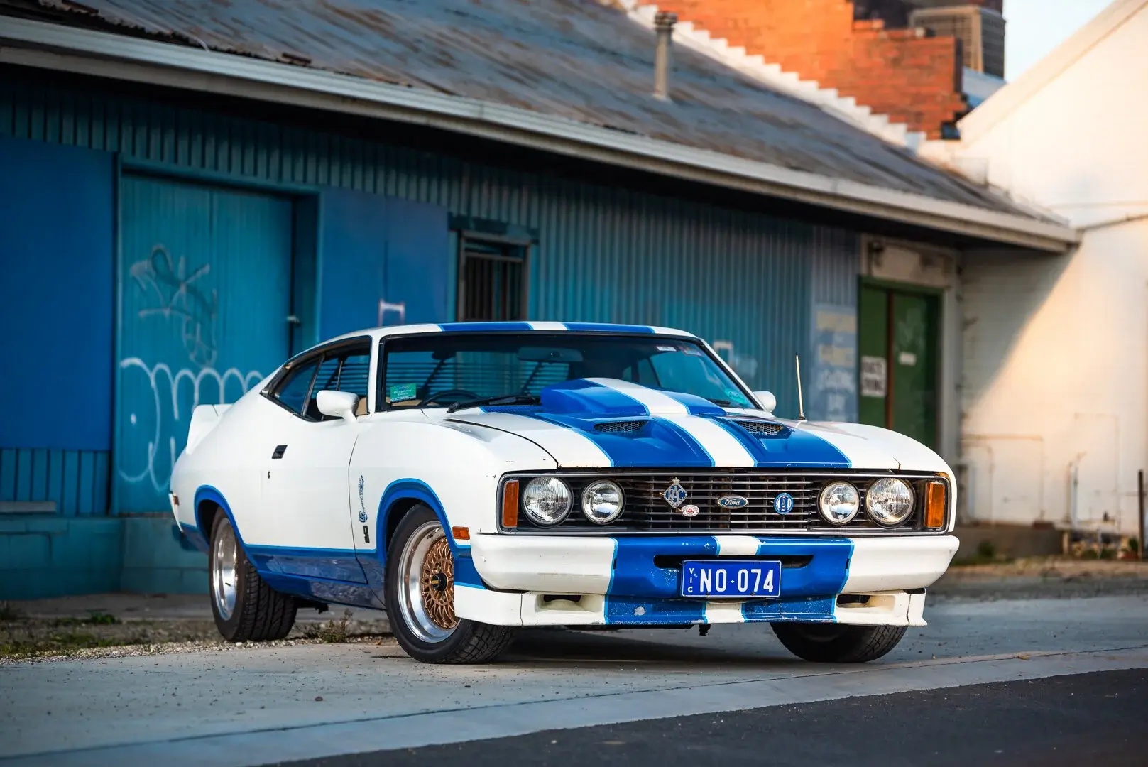 White and blue classic Ford photographed on a quiet street