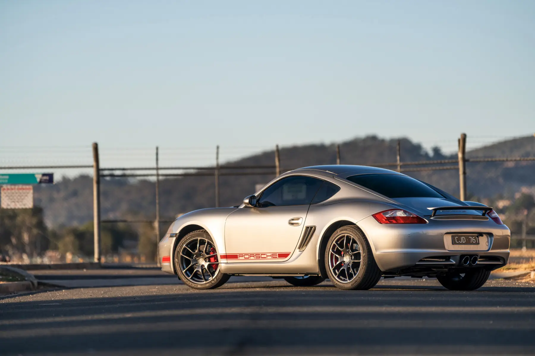 Rear three-quarter view of a silver Porsche Cayman